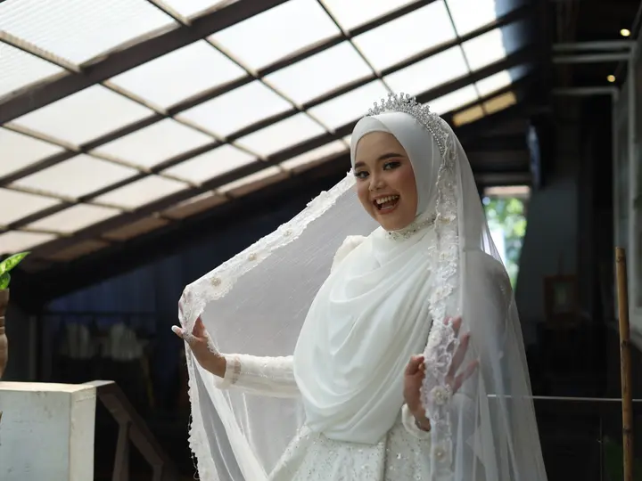 Potret bahagia pengantin wanita dalam balutan busana pengantin dan veil